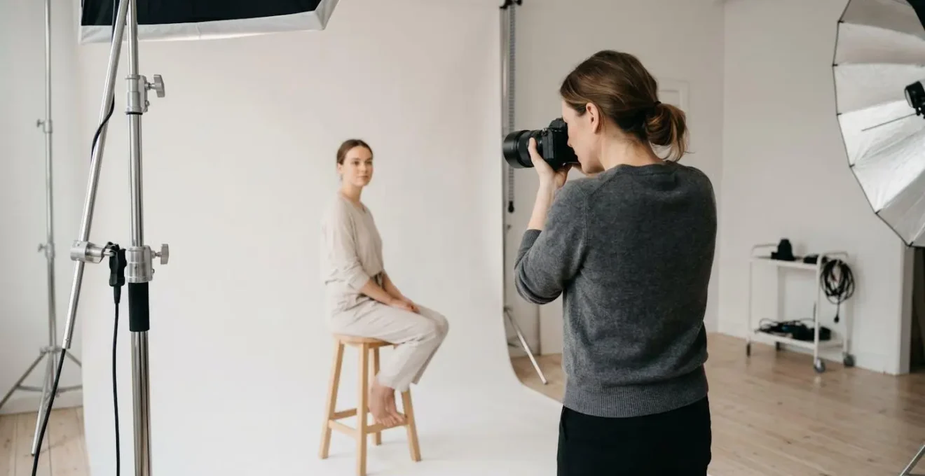 Photographe en studio professionnel utilisant un objectif fixe 85mm pour réaliser un portrait avec éclairage maîtrisé